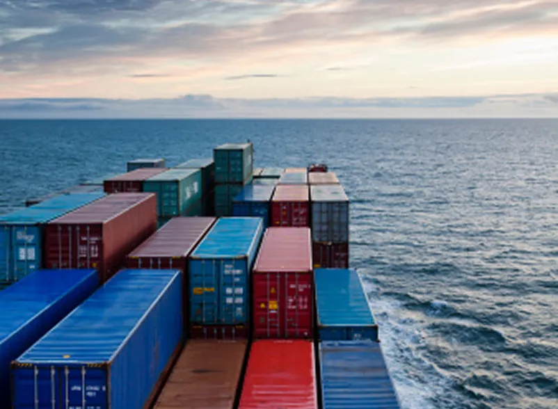 A large, maritime cargo ship moves steadily across open ocean waters.