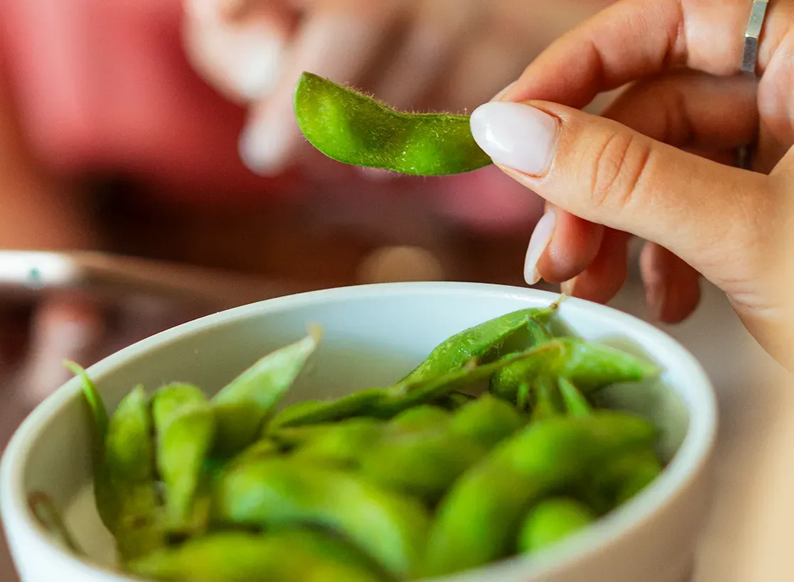 Image of person holding edamame.