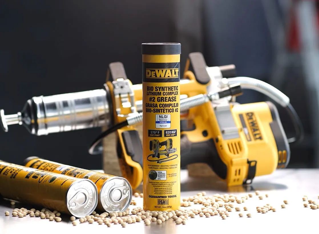 Tubes of DeWalt bio-synthetic grease are displayed on a workbench surrounded by scattered soybeans and power tools.