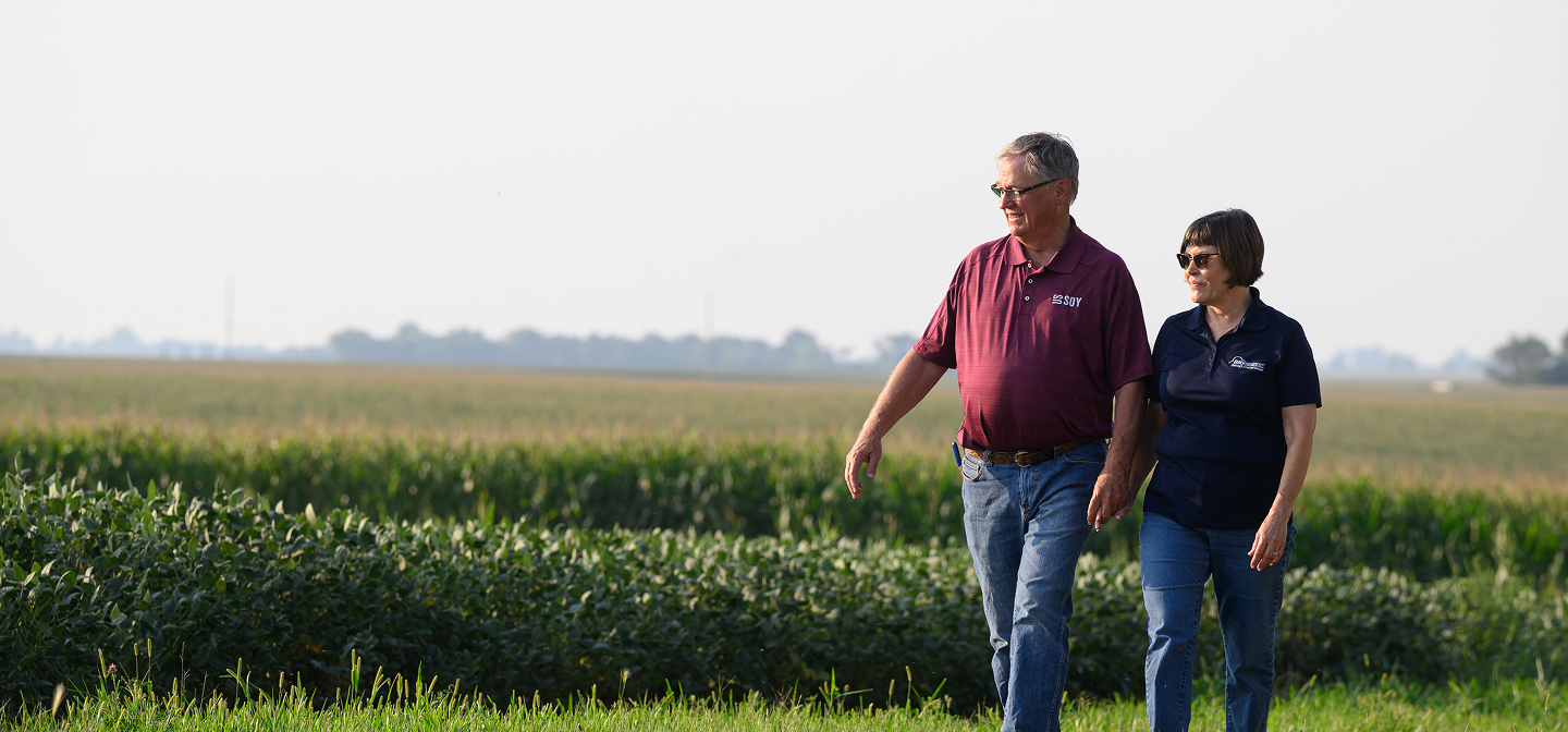 couple walking in front of farm crops