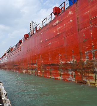 dockside viewing a large red barge